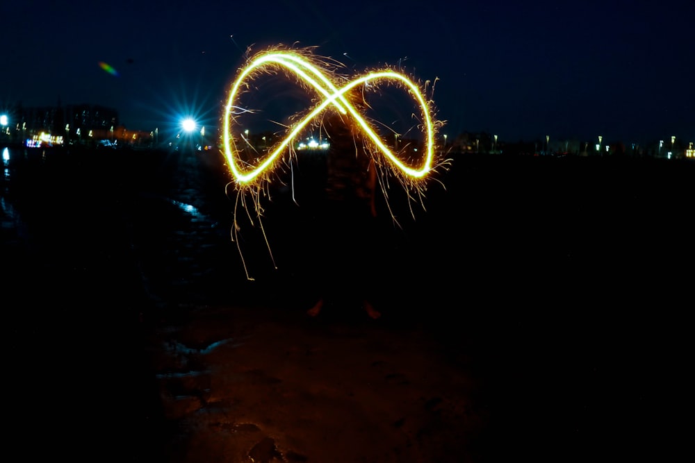 a person holding a sparkler in their hand at night
