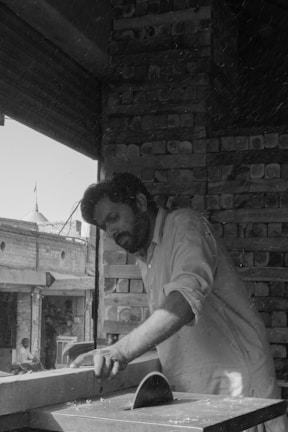 a man in an apron is working on a piece of wood