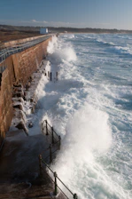 a large body of water next to a brick wall