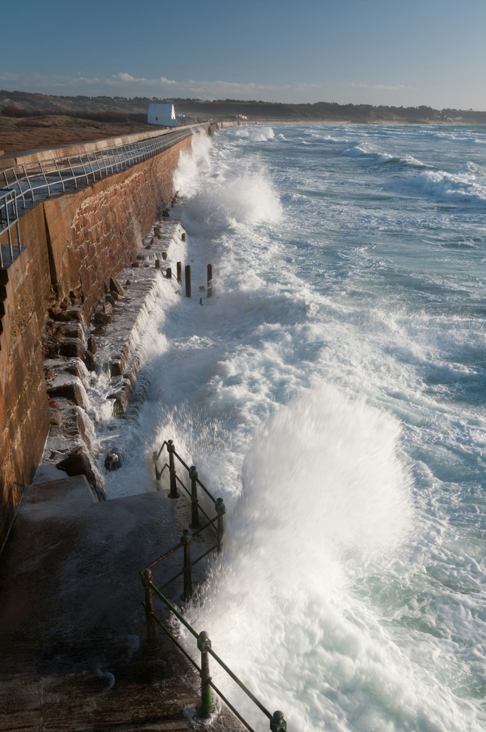 a large body of water next to a brick wall