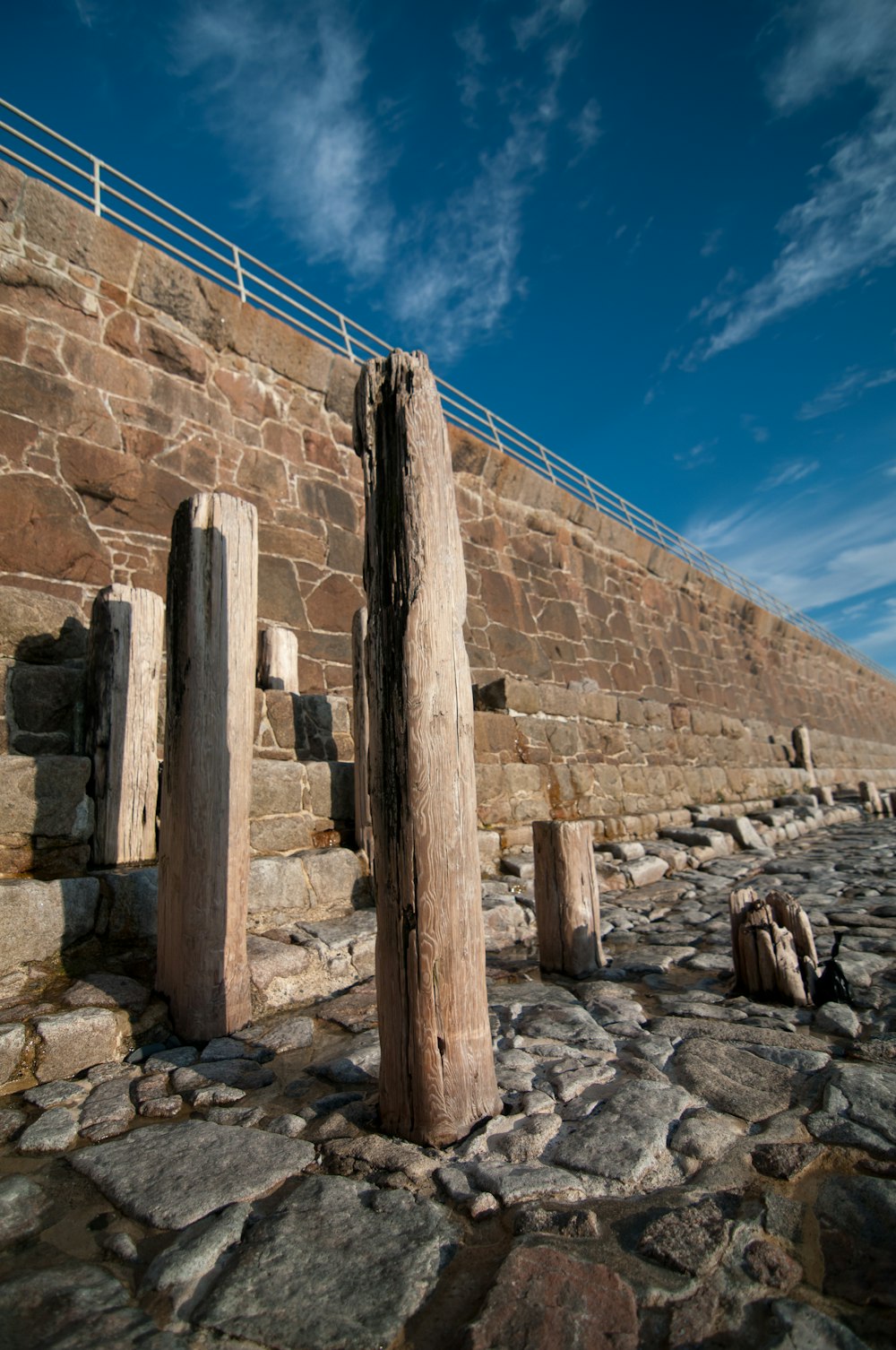 um par de postes de madeira sentados em cima de um chão de pedra
