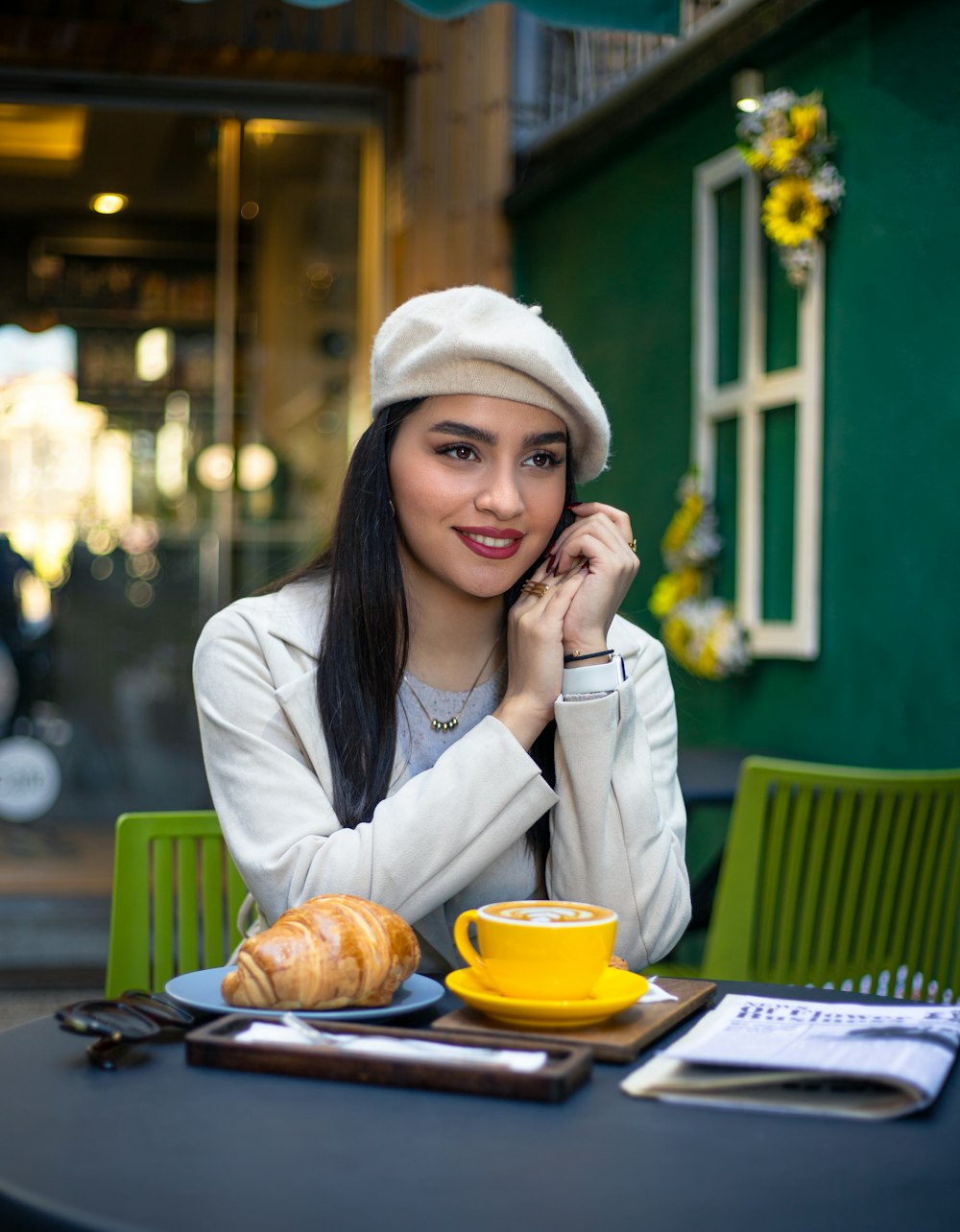 a woman sitting at a table with a cup of coffee