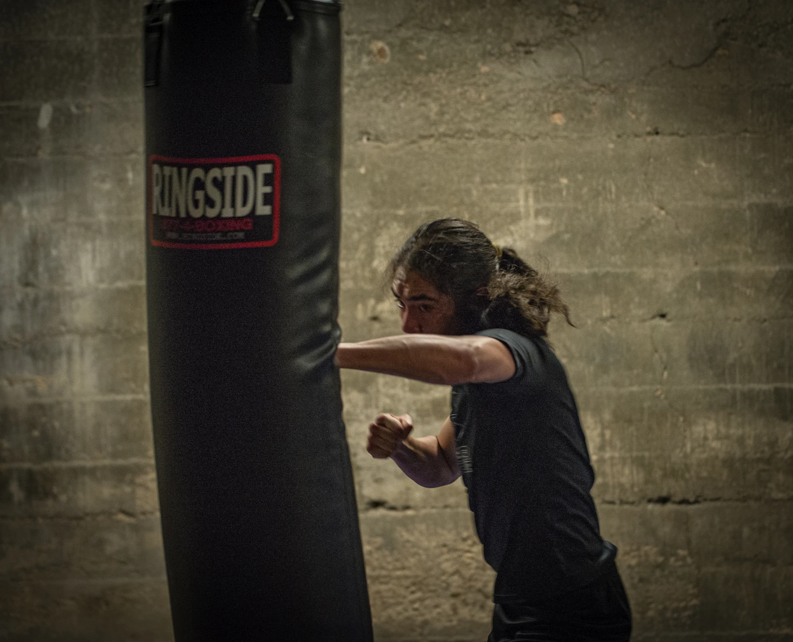 A fighter hitting a heavy bag during a conditioning round