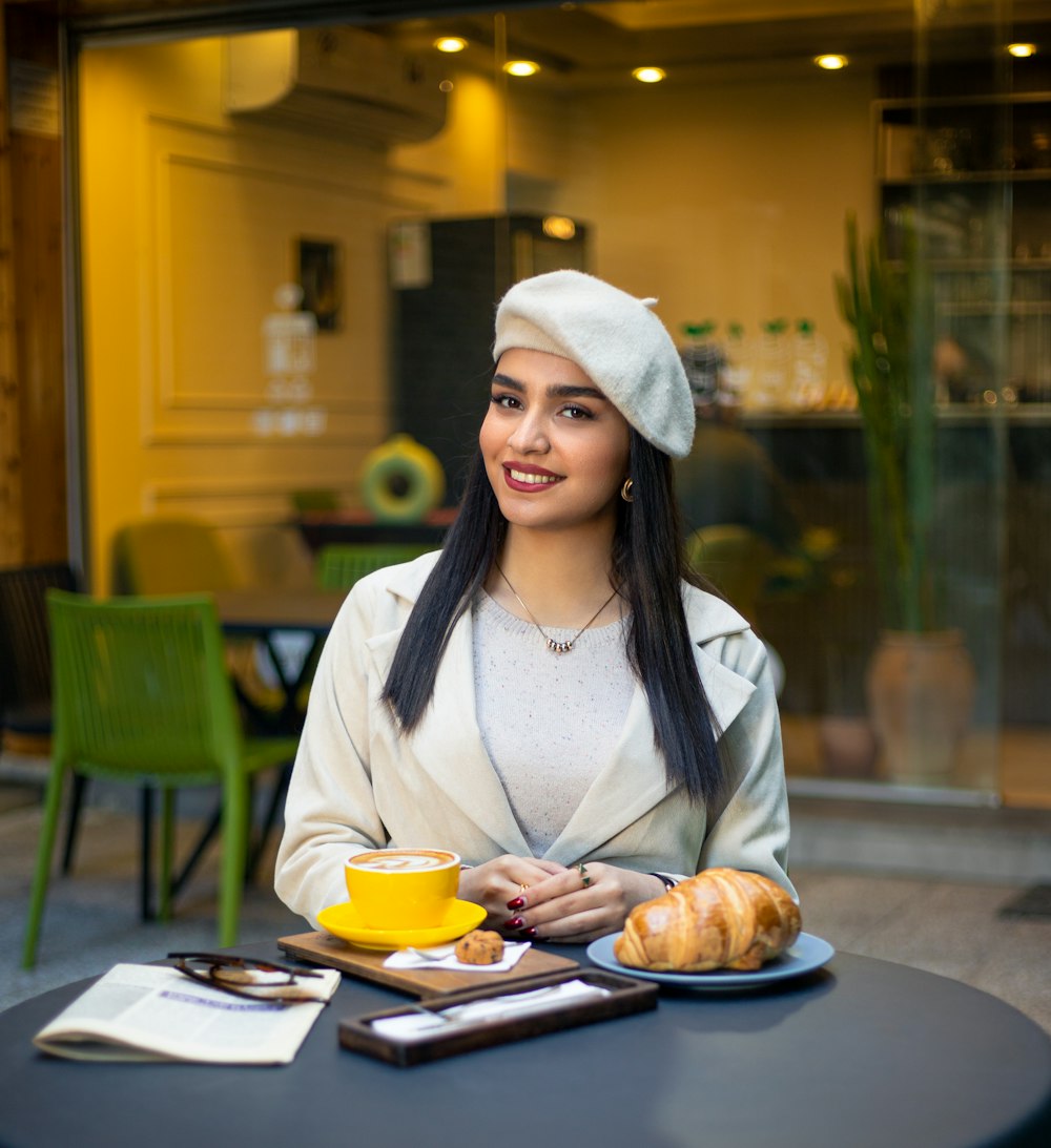 a woman sitting at a table with a plate of food