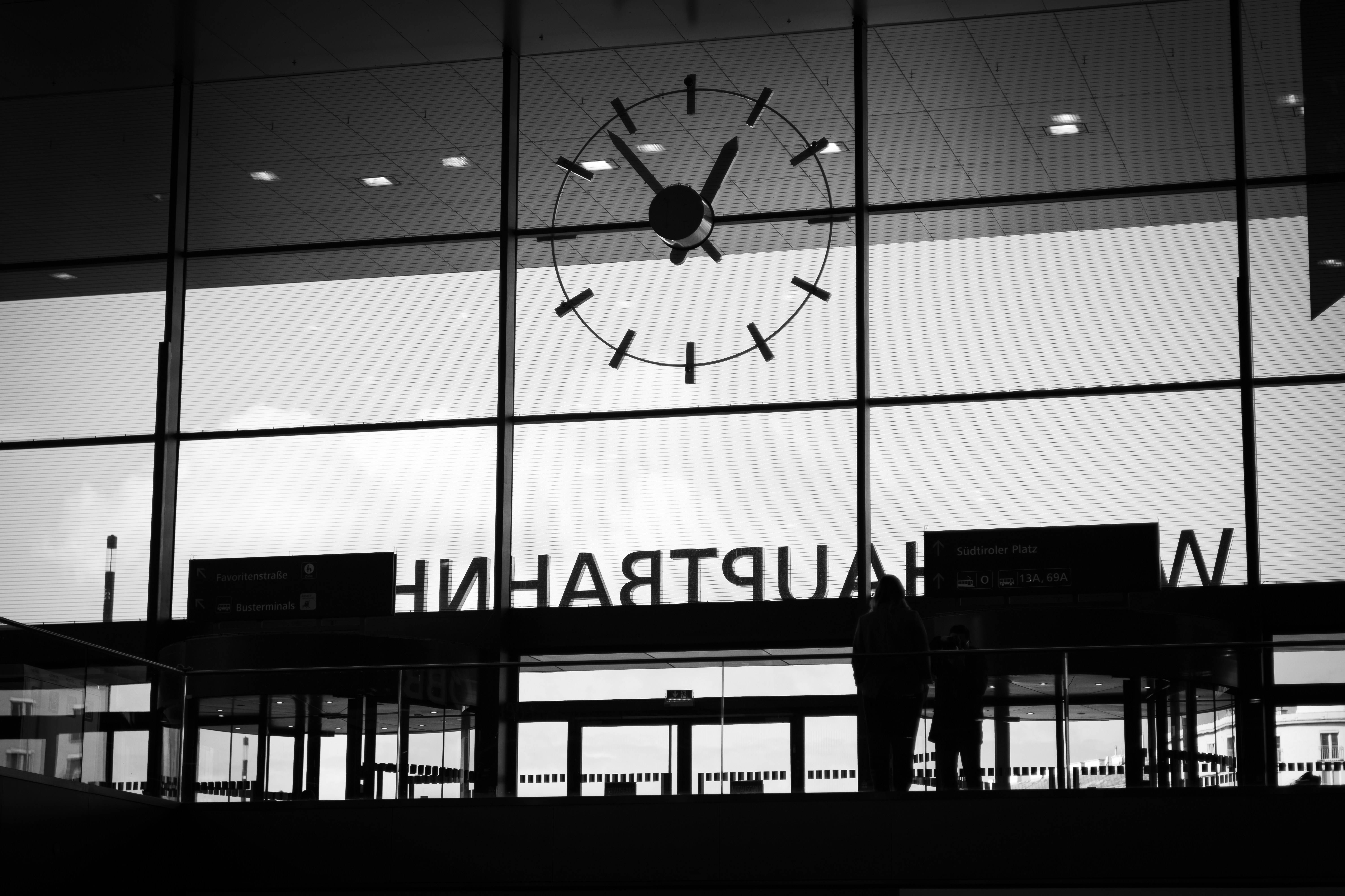 a person standing in front of a building with a clock