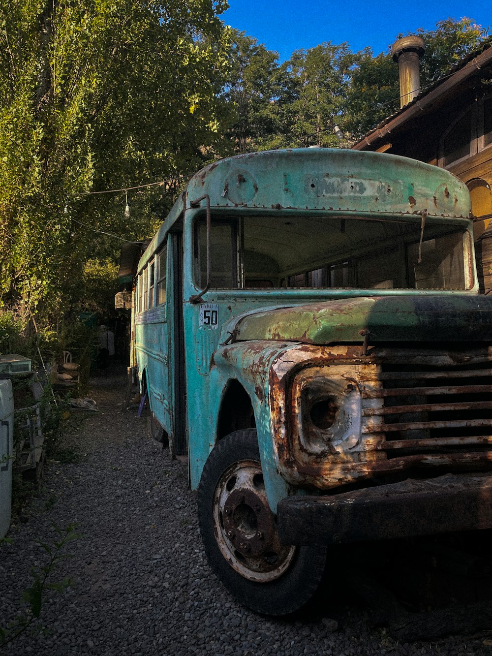 an old rusty school bus sitting in a yard