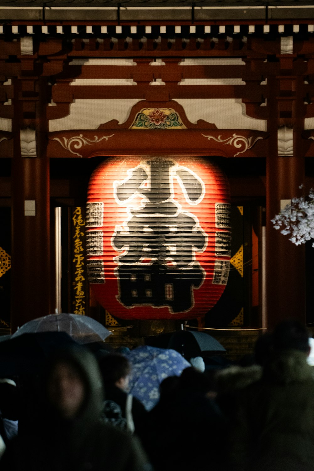 a group of people standing under umbrellas under a building