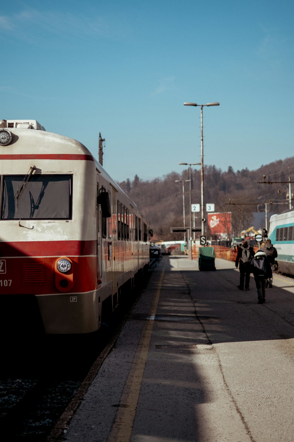 a red and white train traveling down train tracks