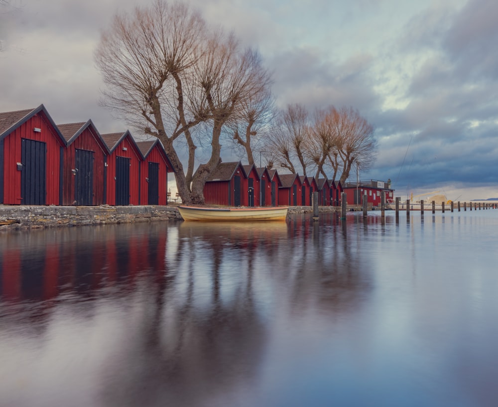 a row of red houses sitting next to a body of water