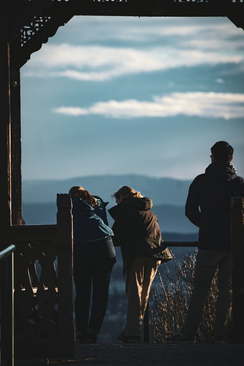 a group of people standing on top of a wooden bridge