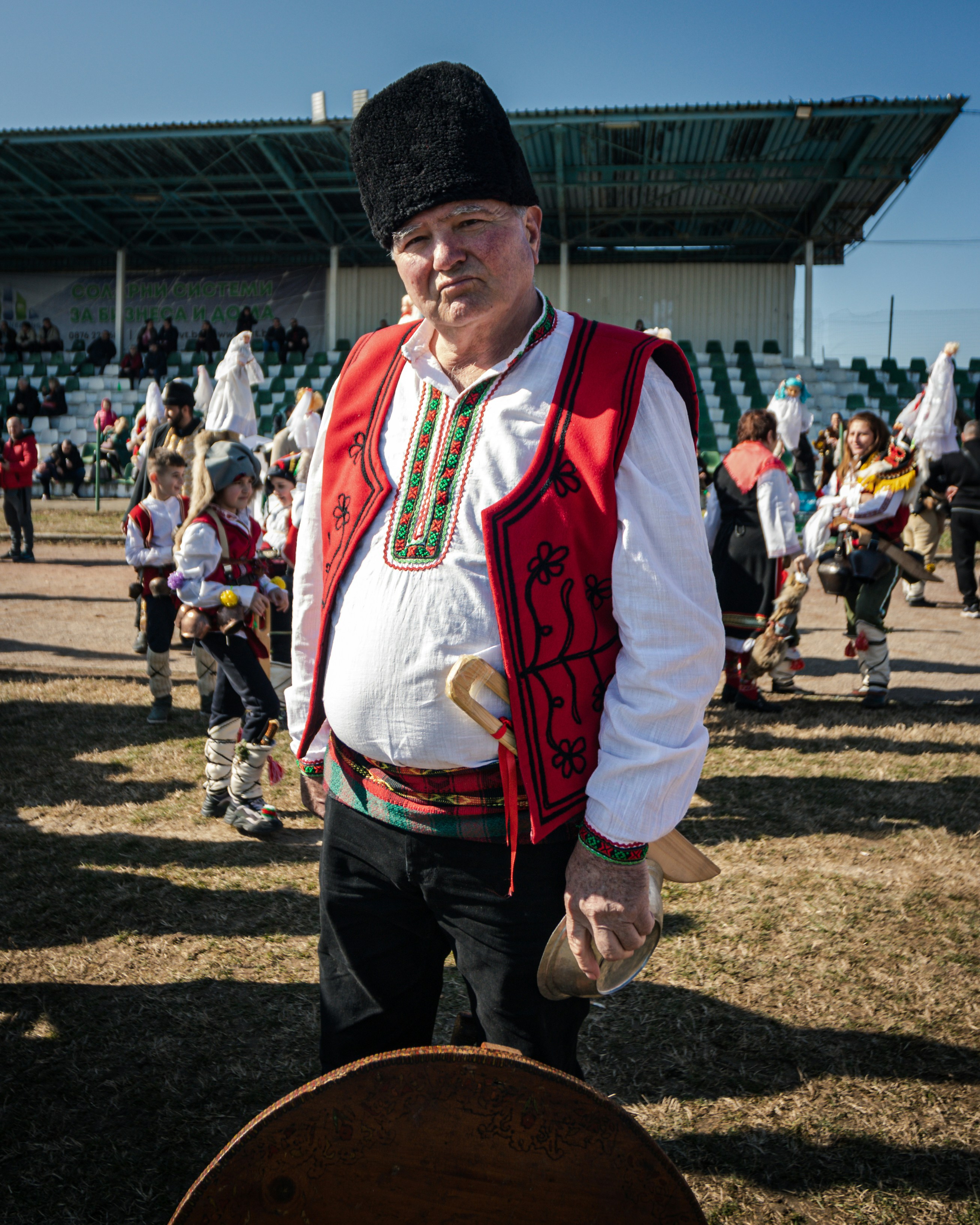 A man wearing a red vest and a black hat