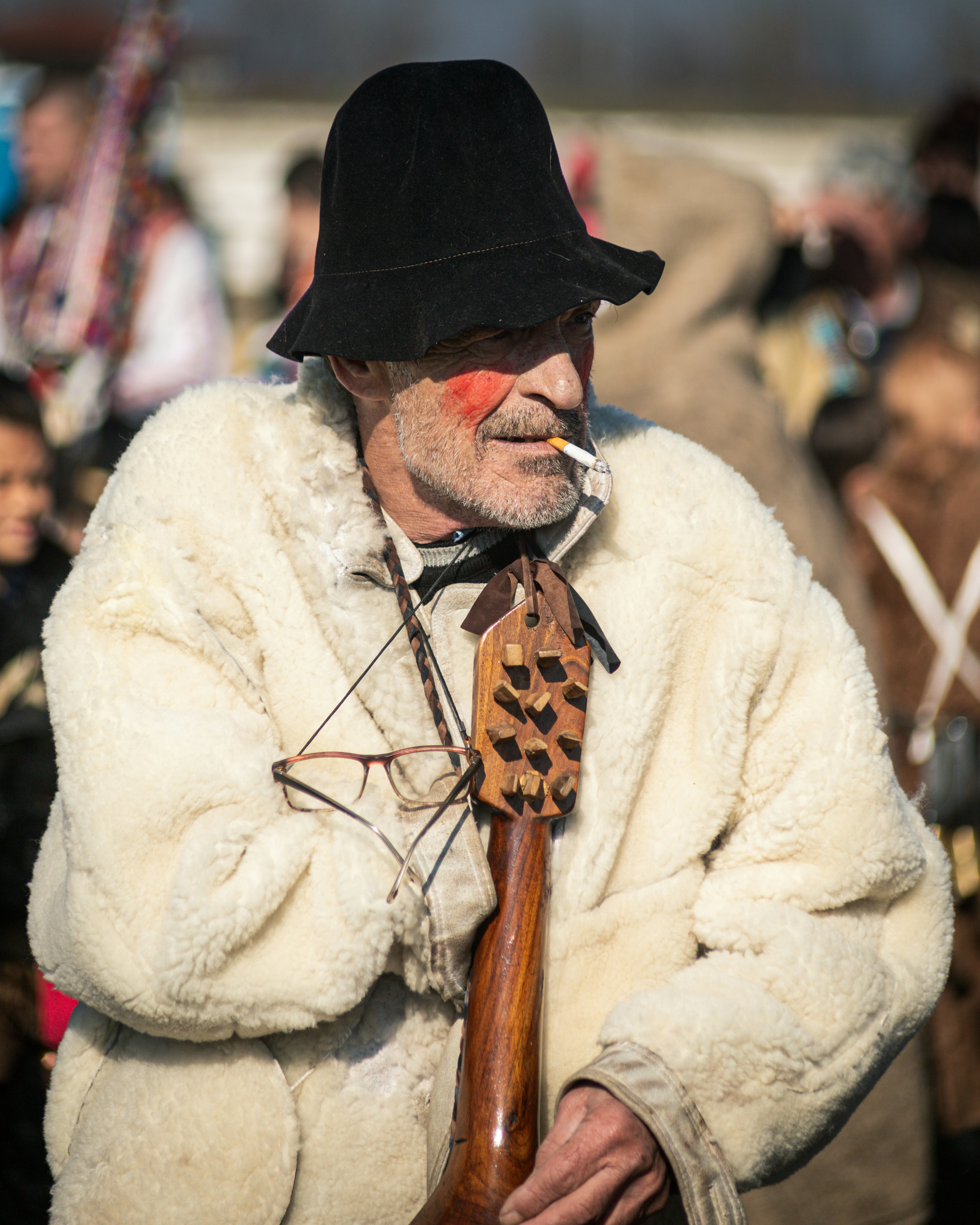 A man in a fur coat smoking a cigarette
