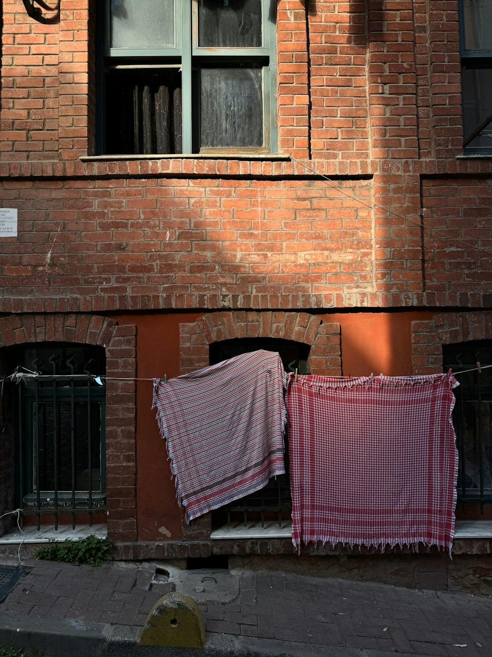 um prédio de tijolos vermelhos com roupas penduradas para secar