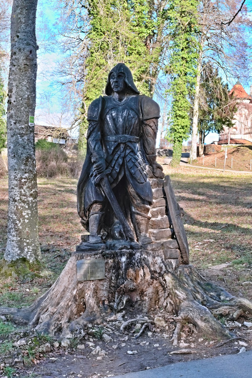 a statue of a woman sitting on top of a tree stump