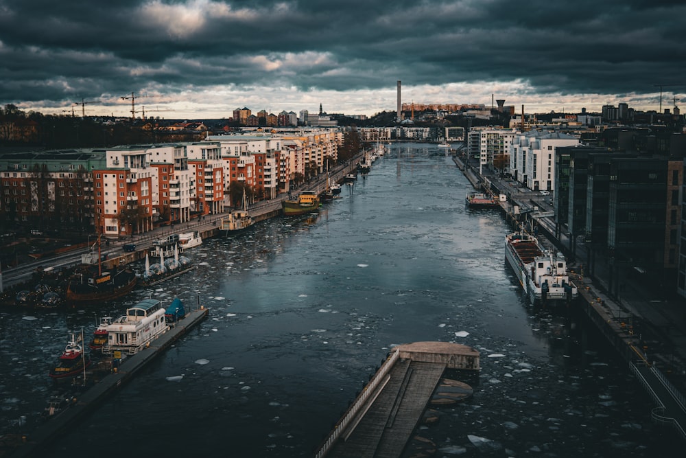 a river running through a city under a cloudy sky