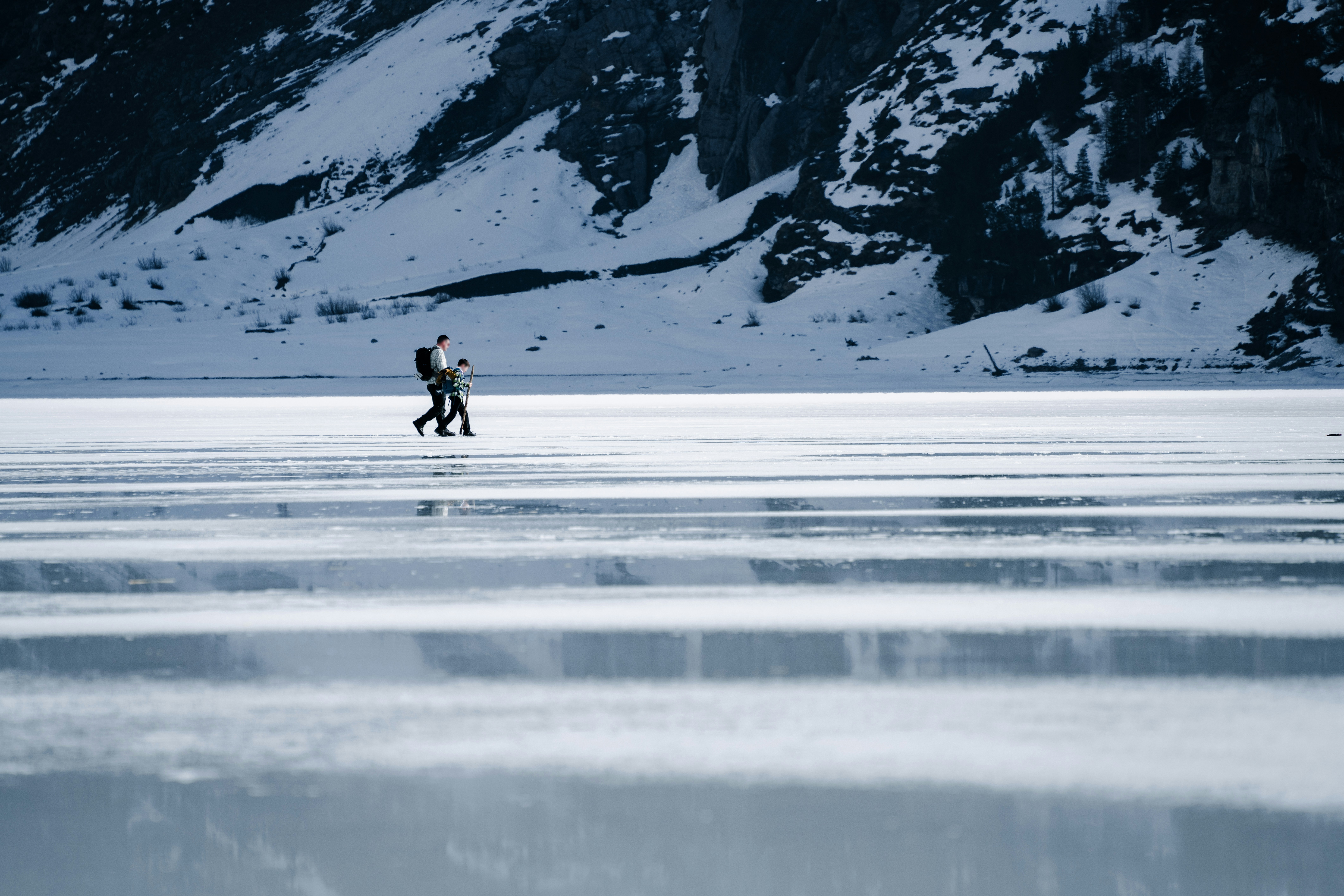 Father and child hiking on frozen lake