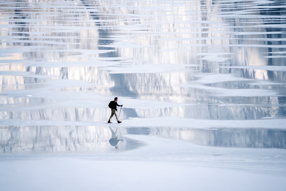 a man walking across a snow covered field