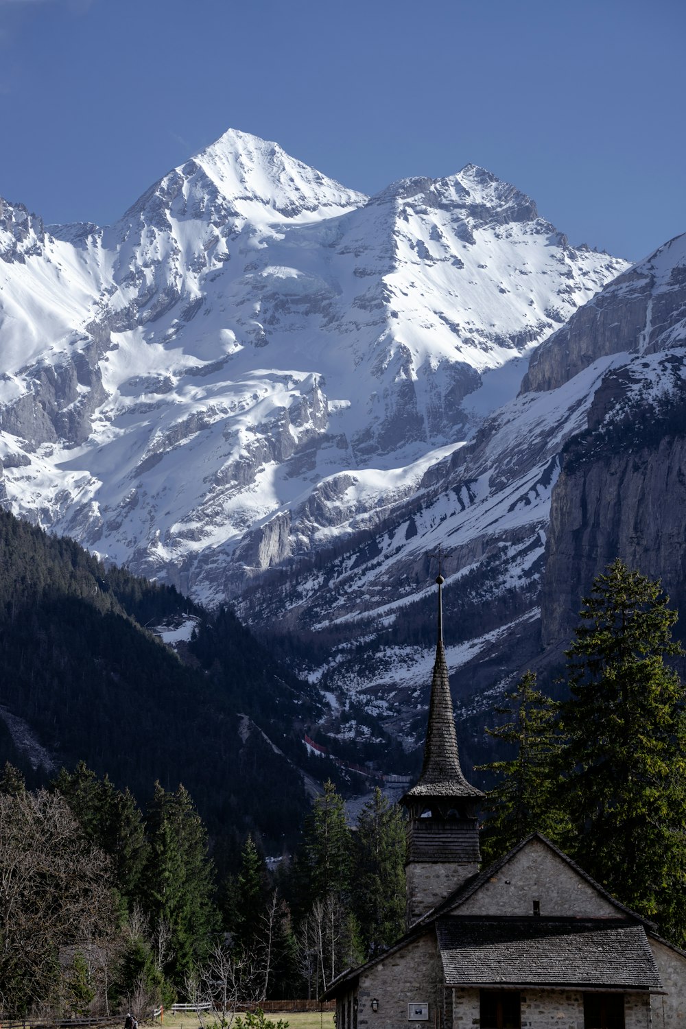 uma igreja em frente a uma cordilheira nevada