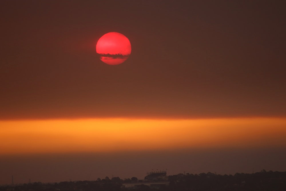 the sun is setting over the horizon of a city