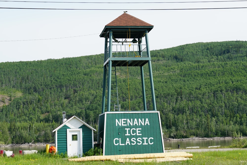 a green tower with a sign in front of it