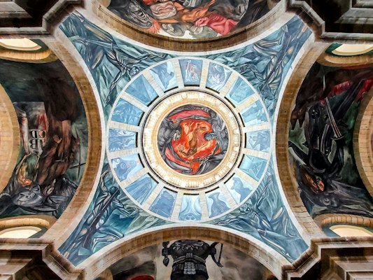 The ceiling of a building with paintings on it — Guadalajara, Mexico