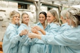 a group of women standing around each other holding wine glasses