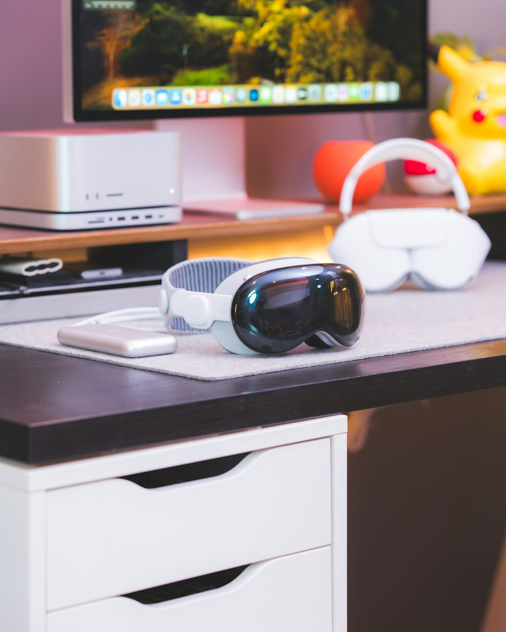 a desk with a computer monitor and a pair of sunglasses on it