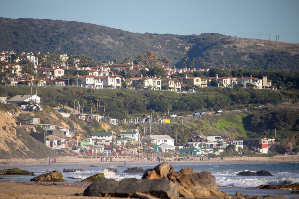 a beach with houses on a hill in the background