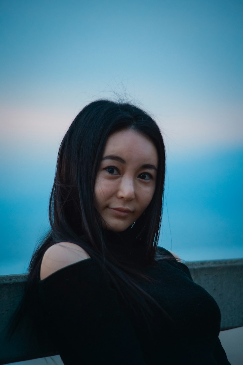 a woman with long black hair posing for a picture