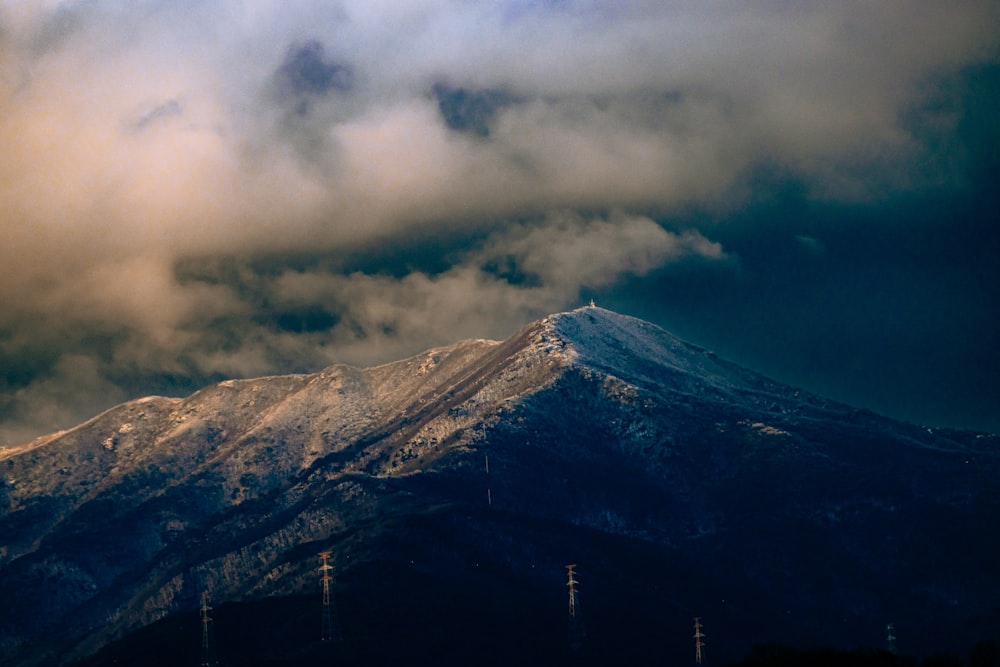 a mountain covered in snow under a cloudy sky