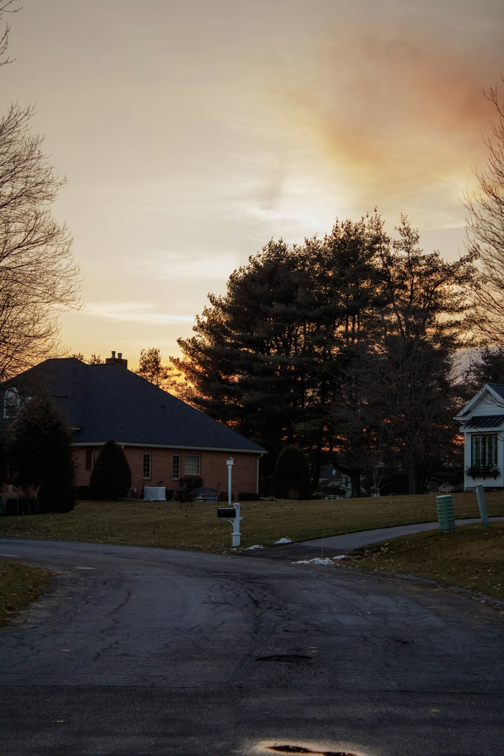 the sun is setting over a house and trees