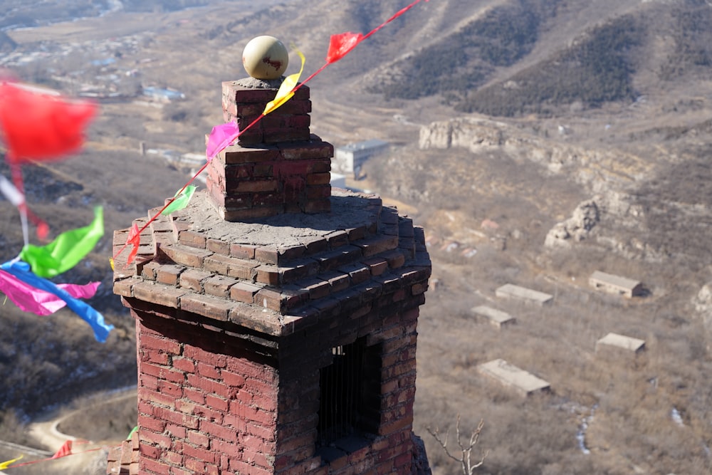 a brick chimney with a ball on top of it