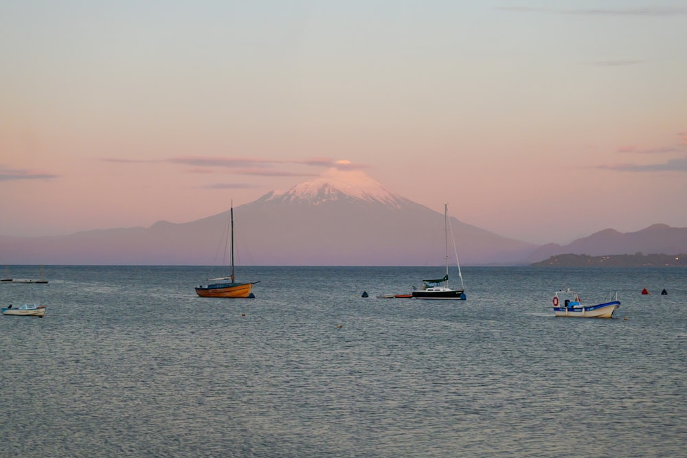 a group of boats floating on top of a large body of water