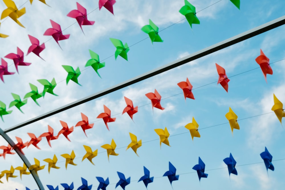 a bunch of colorful paper birds hanging from a wire