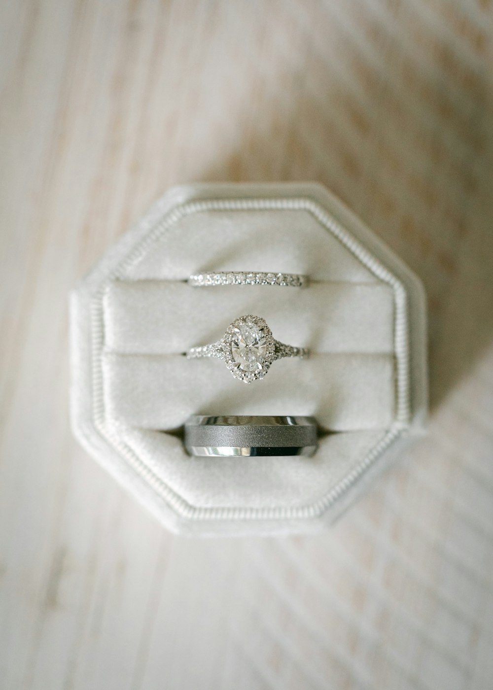a diamond ring sits in a white velvet box