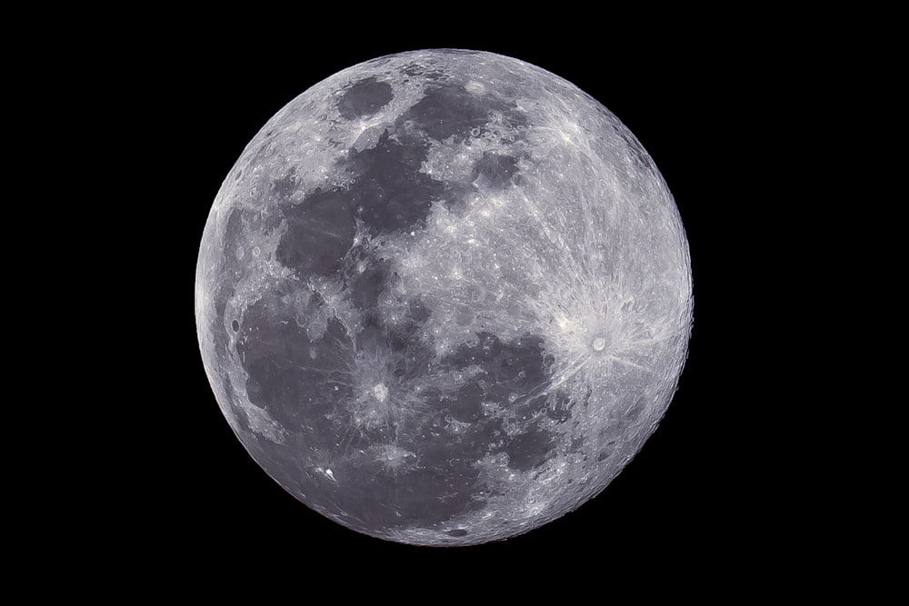 a full moon is shown in the dark sky