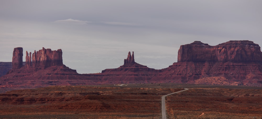 a road going through a desert with mountains in the background