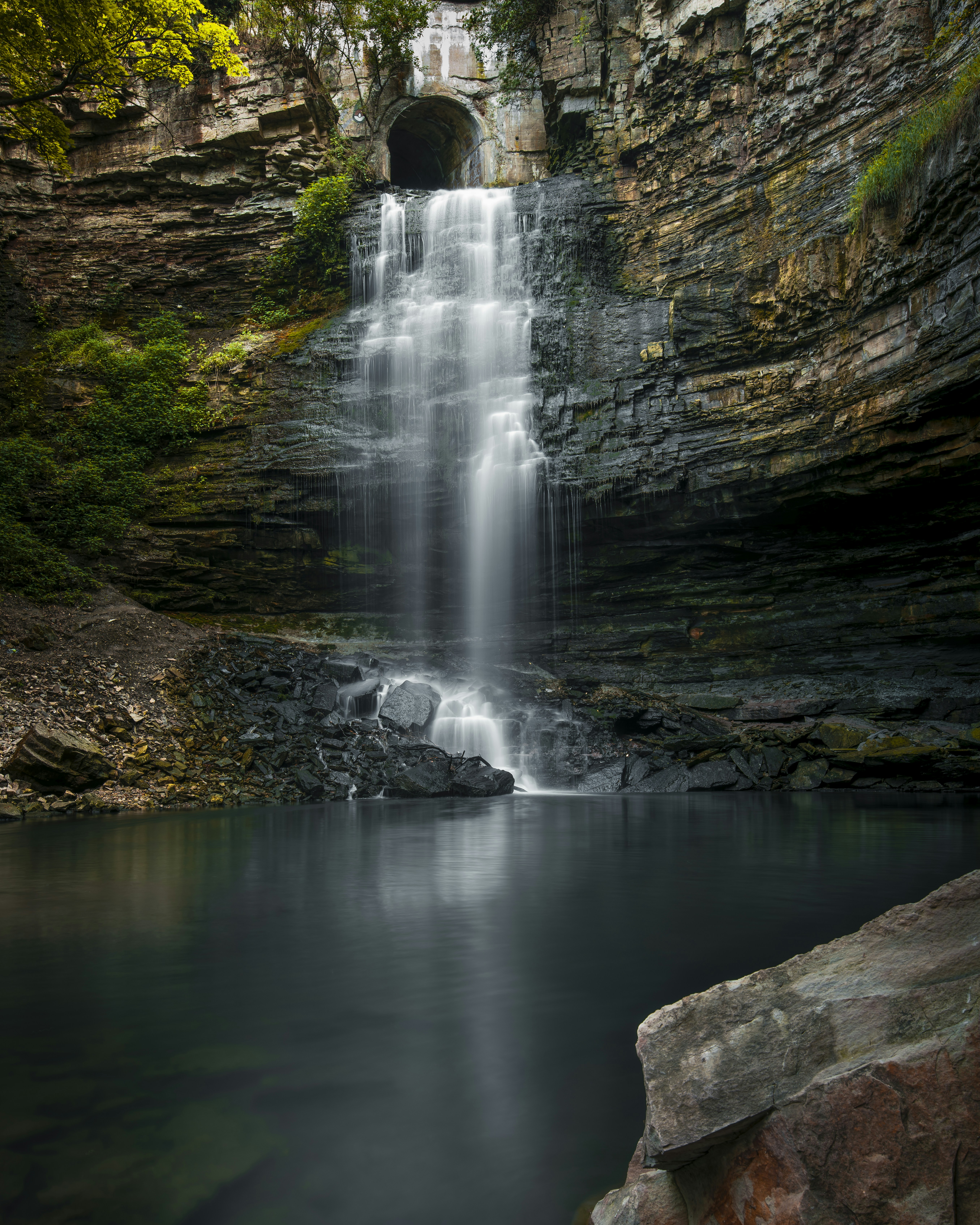 A waterfall with a tunnel in the middle of it photo – Free Wallpaper ...