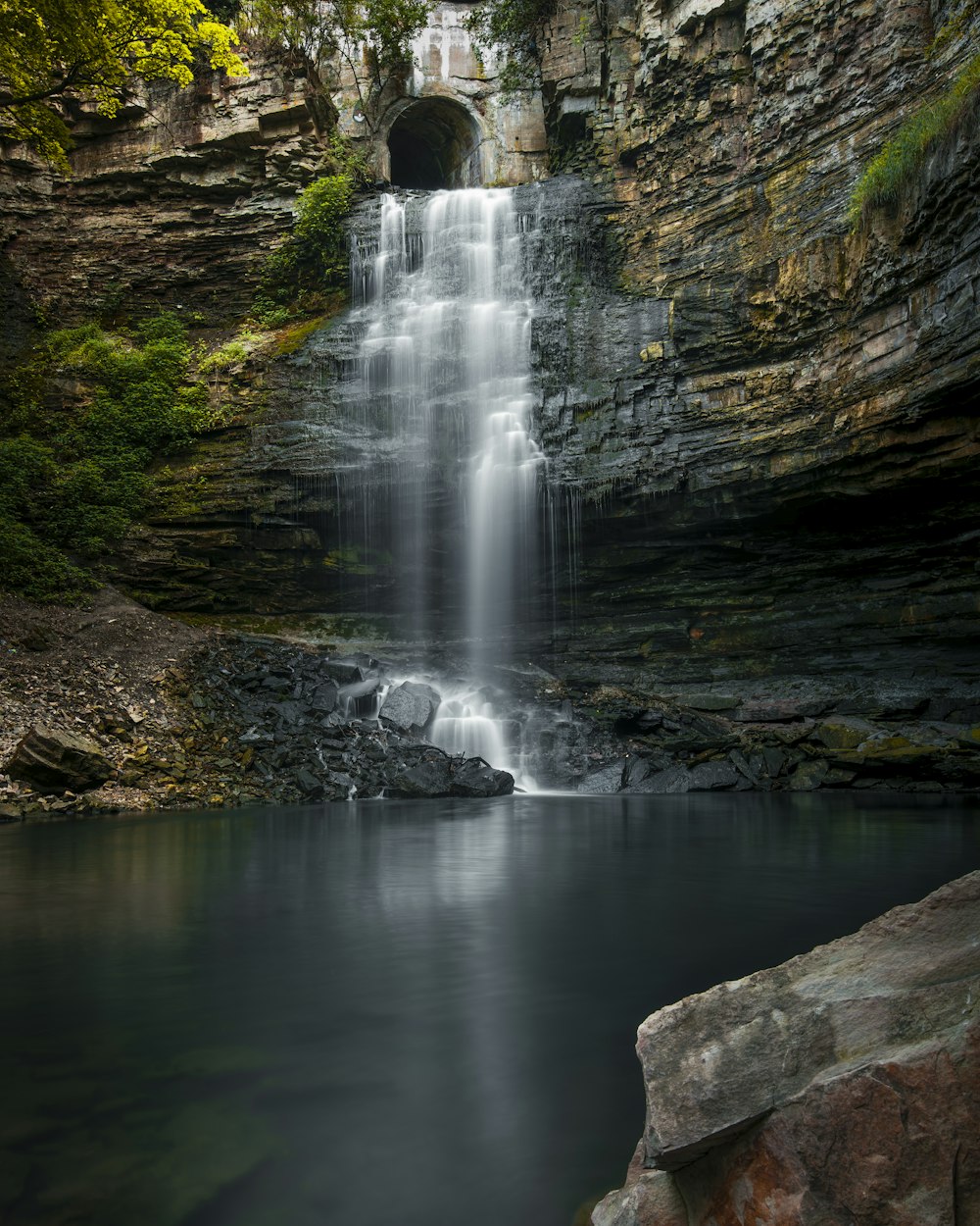 a waterfall with a tunnel in the middle of it