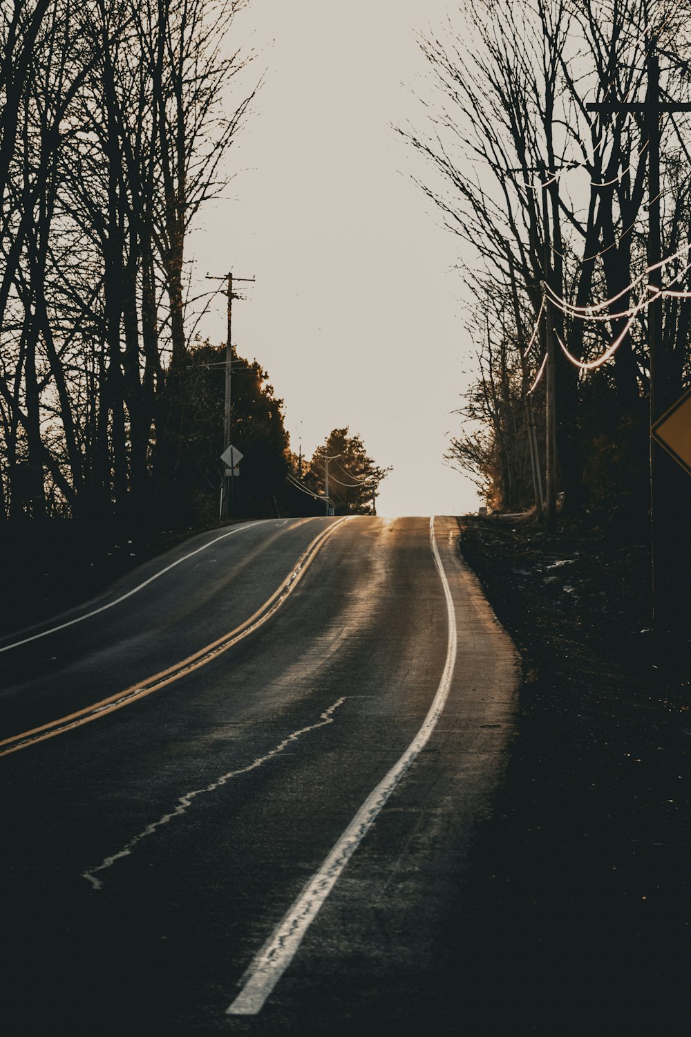 an empty road with a street sign on the side of it