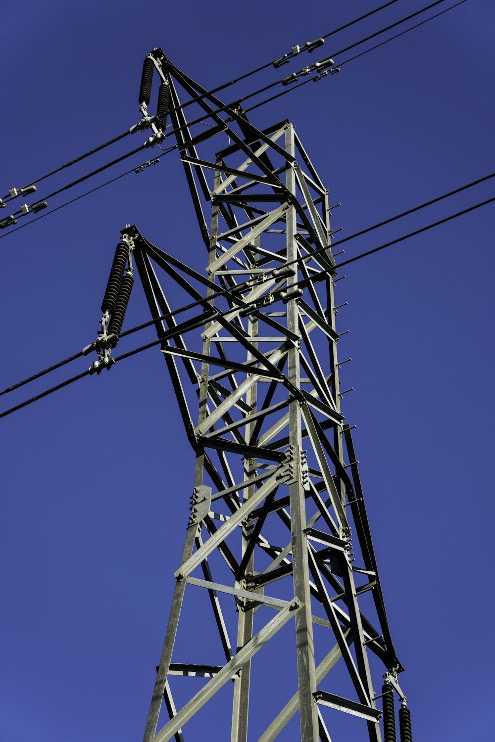 a tall metal tower with lots of wires above it