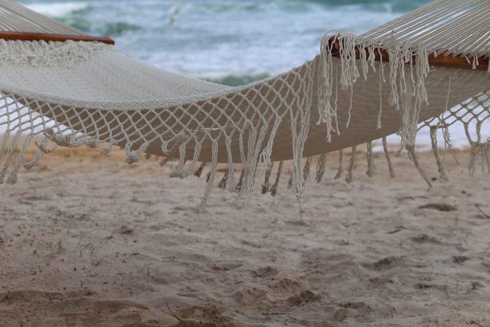 a couple of hammocks sitting on top of a sandy beach