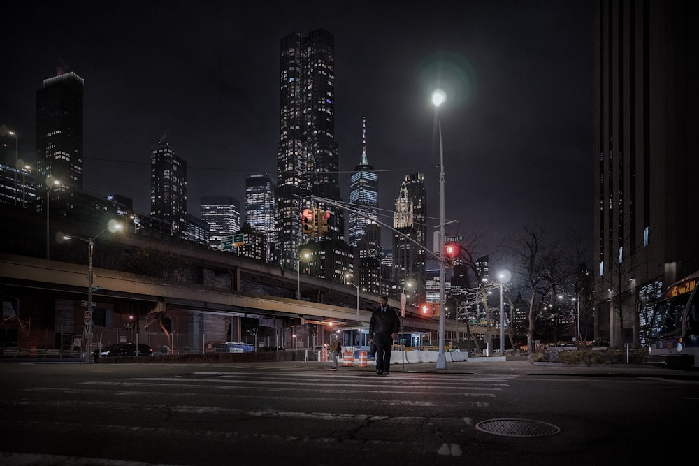 a man standing in the middle of a street at night