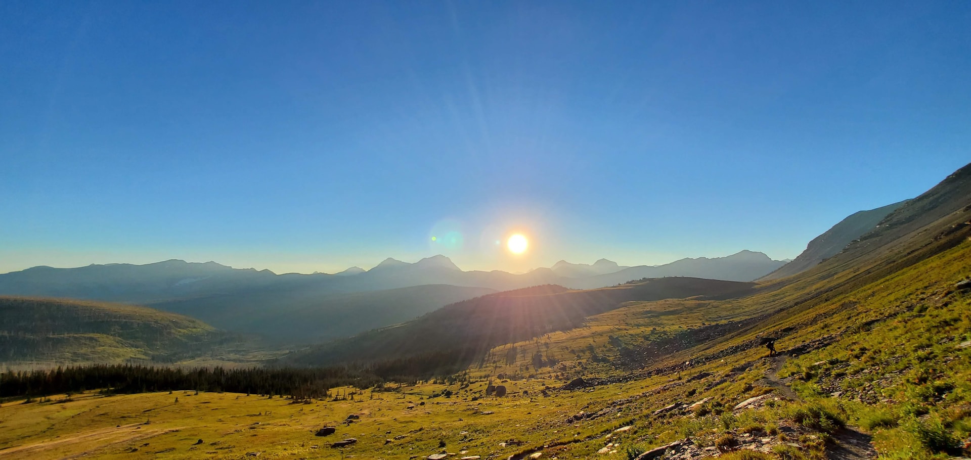 the sun is setting over a mountain range