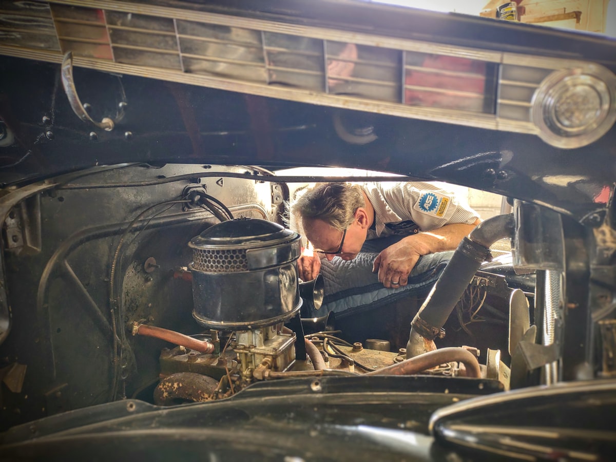 Professional mechanic checking and topping off vehicle fluids for winter car maintenance