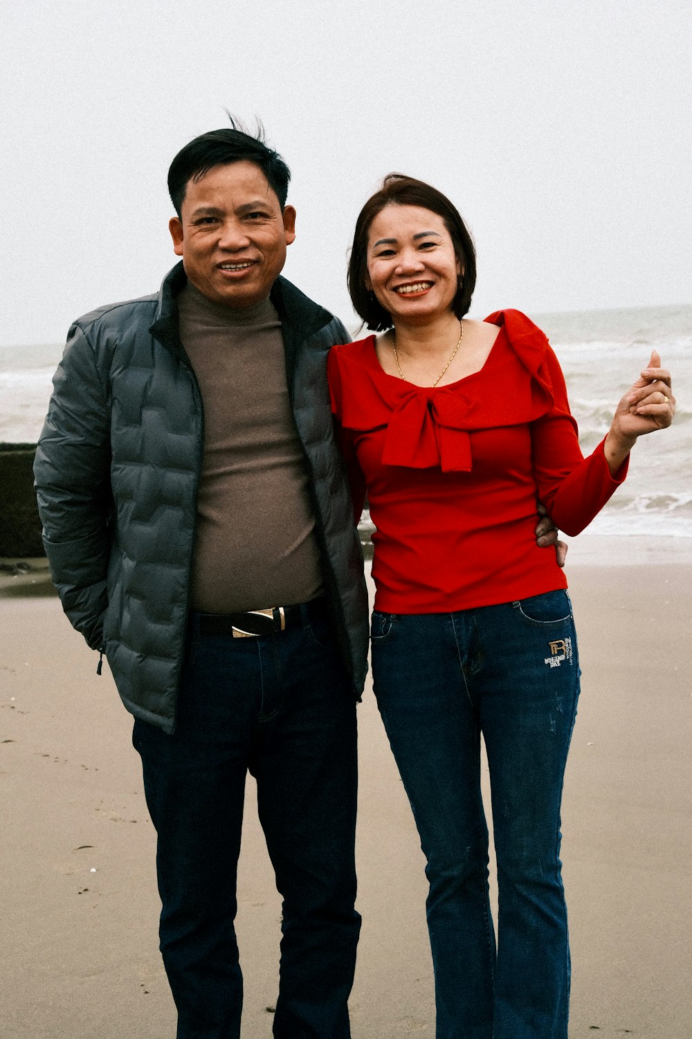 a man standing next to a woman on a beach