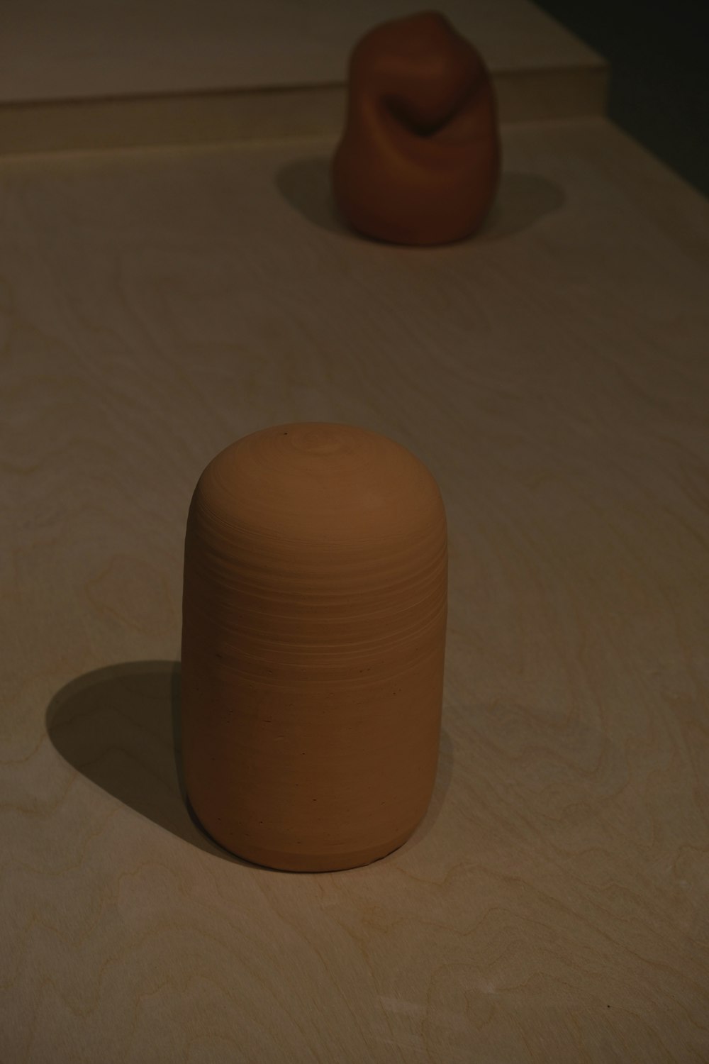 a brown vase sitting on top of a wooden table