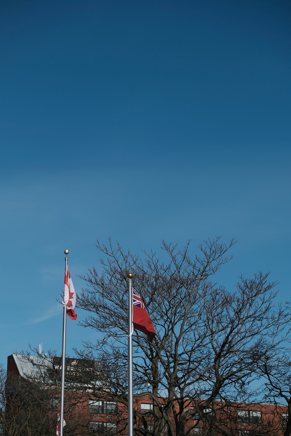 two flags are flying in front of a building