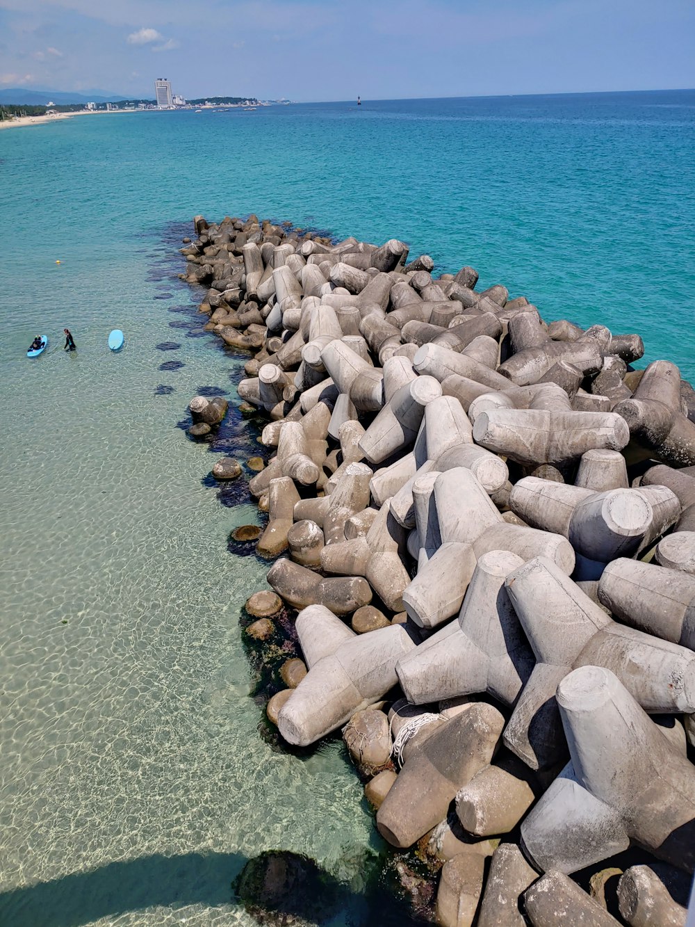 a man standing on a rock wall next to the ocean