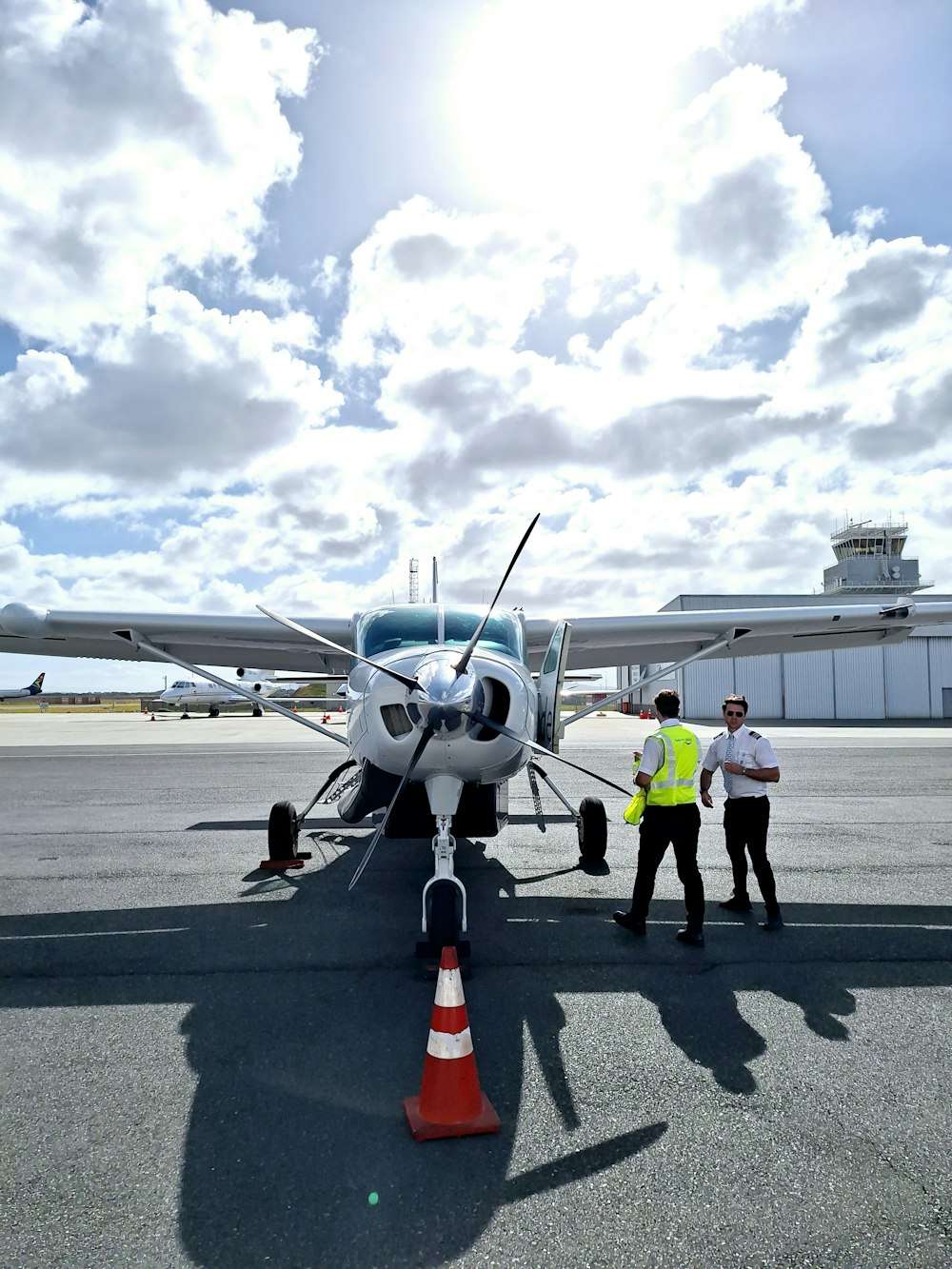 a couple of men standing next to an airplane